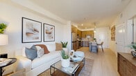 Located at 1575 Camino Altezza in Chula Vista, CA, this thoughtfully designed single-floor residence offers a cohesive blend of modern finishes and functional living spaces. The open-concept living and dining area is bright and welcoming, featuring light wood-tone flooring, large windows that invite natural light, and neutral walls that create a clean, airy ambiance.

The kitchen is a standout feature, showcasing warm wood-grain cabinetry extending to the upper walls, quartz countertops, a subway tile backsplash, and a full suite of stainless steel appliances including a gas range, dishwasher, microwave, and refrigerator. A breakfast bar island provides additional seating and workspace.

The bedroom is generously proportioned with plush carpeting, natural light from a window with outdoor views, and ample room for a full furniture arrangement. The bathroom is finished with a wood-grain vanity, quartz countertops, a soaking tub, and light tile flooring, and connects directly to a walk-in closet with built-in shelving and hanging space.

A dedicated laundry closet houses a stacked washer and dryer unit, adding everyday convenience. Open shelving in the hallway provides additional storage. The overall design palette of warm neutrals, natural wood tones, and modern fixtures creates a polished and comfortable living environment.