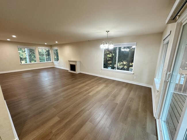 Spacious living room with lots of lights with brand new vinyl flooring and wooden blinds. - 17731 NE 88th Pl