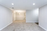 Located at 875 Garden Walk Blvd in Atlanta, Georgia, this single-floor unit offers a practical and well-organized layout suited for comfortable everyday living. The galley-style kitchen is a functional highlight, featuring white cabinetry, light granite-style countertops, wood-look flooring, and black appliances including a refrigerator, electric range, and dishwasher — all arranged efficiently along parallel walls with a window at the end providing natural light. The open living and dining areas flow seamlessly together, with soft neutral-toned carpet underfoot, recessed lighting, and a pendant light fixture that adds a touch of warmth to the dining space. Large windows in the living area allow natural light to filter in, enhancing the airy feel of the space. The bedrooms are carpeted and finished in neutral tones, each with ceiling fans or lighting fixtures and window blinds. The bathrooms are clean and simply appointed, featuring granite-style countertops, white cabinetry, and a bathtub/shower combination with a curtain rod. Throughout the unit, consistent neutral wall tones, white baseboards, and textured ceilings create a cohesive and move-in-ready aesthetic.