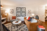 This well-appointed single-floor residence at 650 Route 23 in Wayne, NJ offers a cohesive and stylish living experience across a thoughtfully laid-out floor plan. The living area is warm and inviting, featuring rich hardwood flooring, crown molding, and a built-in media console with open shelving — ideal for displaying books and décor. Natural light filters in through a window dressed with patterned curtains, creating a cozy yet functional space for relaxing or entertaining.

The kitchen is designed for both style and practicality, showcasing dark espresso cabinetry, granite countertops with subtle veining, and a full suite of stainless steel appliances including a range, over-the-range microwave, and refrigerator. The hardwood floors carry through seamlessly from the living area, reinforcing the space's visual continuity.

The bedroom offers a calm and comfortable retreat, with soft carpeting, ample closet space, and room for generous furnishings. Neutral walls provide a versatile backdrop, complemented by warm lighting fixtures.

The bathroom is finished with dark-toned cabinetry, granite countertops, a framed mirror, and a full tub-shower combination with clean white tile surround — balancing elegance with everyday functionality. Overall, this residence presents a well-balanced and move-in-ready living environment.