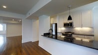 Located at 1530 Locust Street in the heart of Center City Philadelphia, this single-floor residence combines contemporary design with refined finishes throughout. The open-concept layout connects living and kitchen areas seamlessly, creating a spacious and inviting atmosphere.

The kitchen is a standout feature, equipped with stainless steel appliances including a gas range, microwave, and refrigerator. Crisp white shaker-style cabinetry pairs elegantly with dark granite countertops, while a classic subway tile backsplash adds texture and visual interest. A peninsula with a double sink and matching dark granite surface provides additional prep space and serves as a natural divider between the kitchen and living area. A sleek pendant light overhead adds a modern, focused accent.

Rich hardwood flooring runs throughout the space, lending warmth and continuity to each area. Clean white walls and architectural details such as crown molding and substantial baseboards contribute to the polished, classic aesthetic. The open sightlines between rooms enhance the sense of spaciousness, making the layout both functional and visually appealing.

Situated in one of Philadelphia's most walkable and dynamic neighborhoods, this residence offers convenient access to dining, shopping, cultural institutions, and public transportation.