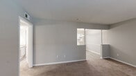 Located at 50 Glenwood Rd in Greenville, SC, this single-floor, one-bedroom, two-bathroom residence offers a thoughtfully organized layout across a compact yet efficient footprint. The living room features neutral gray walls, soft carpeting, and an open pass-through to the kitchen, creating a connected and airy feel. Natural light filters in through blinds-covered windows, enhancing the bright, clean aesthetic throughout.

The kitchen is a standout feature, boasting white cabinetry, granite-look countertops, a tile backsplash, and dark appliances including a range and dishwasher. Light wood-look flooring and a secondary door with a window add practicality and brightness to the space.

The generously sized bedroom includes a ceiling fan with lighting, a large window for natural light, and direct access to a dedicated vanity area complete with white cabinetry, a granite-topped counter, and a large mirror with overhead lighting — ideal as a dressing space. Two closets provide ample storage throughout the unit.

Both bathrooms are finished with neutral tones and include vanities with granite-style countertops and wood-look flooring. A connecting hallway ties the rooms together seamlessly, offering a functional and comfortable flow throughout this well-maintained Greenville residence.