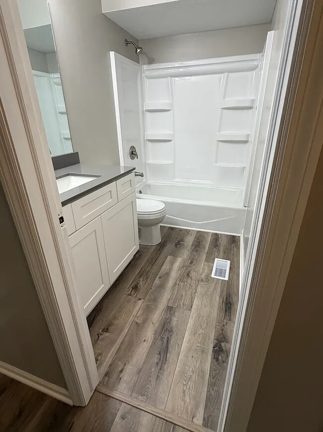 Baño principal con tocador nuevo, lavabo, encimera de cuarzo, grifos, inodoro y ducha. - 6718 S 87th St