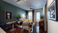 Located at 1505 Demonbreun St in the heart of Nashville, TN, this one-bedroom, one-bathroom apartment offers a thoughtfully designed single-floor layout that balances contemporary style with everyday comfort. Rich hardwood flooring runs throughout, anchoring each room with warmth and continuity.

The living area makes a strong first impression with a deep teal accent wall, ceiling fan with a modern fixture, and track lighting overhead. Large windows dressed with floor-length drapes invite generous natural light while offering privacy, and a welcoming entry door connects directly to the space.

The kitchen is both functional and attractive, featuring dark espresso cabinetry, granite countertops, a mosaic tile backsplash, stainless steel appliances, and a peninsula with bar seating illuminated by pendant lighting — ideal for casual dining and entertaining.

The bedroom continues the bold design language with a deep blue-green accent wall, large windows allowing ample natural light, hardwood floors, and room for a full furniture arrangement.

The bathroom is cleanly appointed with dark cabinetry, a granite vanity, a walk-in shower with glass enclosure, and hardwood-style flooring. Every detail of this apartment reflects a cohesive, modern aesthetic in one of Nashville's most vibrant neighborhoods.