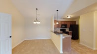This single-floor unit at Overbrook Apartments offers a well-designed, open-concept layout that maximizes both function and comfort. The living area is anchored by soaring vaulted ceilings and is seamlessly connected to the kitchen, creating an airy, expansive feel. A decorative chandelier adds a touch of elegance to the space, while the transition from plush carpeting to tile flooring delineates the living and kitchen areas.

The kitchen is equipped with rich, medium-toned cabinetry, a classic tile backsplash, and a full suite of black appliances including a range, microwave, and refrigerator. A peninsula with a dark countertop and double sink provides additional prep space and casual seating, opening directly to the living area.

The bedrooms are carpeted and finished with neutral-toned walls, offering a calm and versatile environment. The primary bedroom features impressive vaulted ceilings and double doors leading to a spacious closet. Additional bedrooms include windows with blinds that allow for natural light.

Both bathrooms are outfitted with warm wood cabinetry, granite-toned countertops, tub-shower combinations, and tile flooring, delivering a cohesive and functional design. A tiled hallway connects the main living spaces, completing this thoughtfully arranged home.