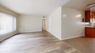 Located at 3902 Lenawee Ave in Culver City, California, this single-story, 3-bedroom, 2-bathroom home offers a well-organized and cohesive layout throughout. The open living room greets you with warm hardwood-style flooring, neutral toned walls, and natural light filtering in through window treatments, creating an inviting and airy atmosphere.

The galley-style kitchen is thoughtfully designed, featuring rich wood cabinetry that extends floor to ceiling, dark granite countertops, a mosaic tile backsplash, stainless steel appliances, and large-format tile flooring. Ample storage and counter space make this kitchen both functional and visually appealing.

Each of the three bedrooms is finished with the same hardwood-style flooring found throughout the home. Ceiling fans are present in the bedrooms, and closets with mirrored sliding doors provide generous storage. The primary bedroom is notably spacious, offering room for comfortable furnishings.

The two bathrooms maintain a consistent design language, featuring wood-tone vanities with dark granite countertops, large-format tile flooring, and clean white fixtures. One bathroom includes a tub-shower combination with full white tile surround and a window for natural light.

A hallway connects the bedrooms and bathrooms efficiently, completing this well-planned single-floor residence in a desirable Culver City location.