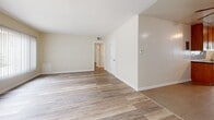 Located at 3902 Lenawee Ave in Culver City, California, this single-story, 3-bedroom, 2-bathroom home offers a well-organized and cohesive layout throughout. The open living room greets you with warm hardwood-style flooring, neutral toned walls, and natural light filtering in through window treatments, creating an inviting and airy atmosphere.

The galley-style kitchen is thoughtfully designed, featuring rich wood cabinetry that extends floor to ceiling, dark granite countertops, a mosaic tile backsplash, stainless steel appliances, and large-format tile flooring. Ample storage and counter space make this kitchen both functional and visually appealing.

Each of the three bedrooms is finished with the same hardwood-style flooring found throughout the home. Ceiling fans are present in the bedrooms, and closets with mirrored sliding doors provide generous storage. The primary bedroom is notably spacious, offering room for comfortable furnishings.

The two bathrooms maintain a consistent design language, featuring wood-tone vanities with dark granite countertops, large-format tile flooring, and clean white fixtures. One bathroom includes a tub-shower combination with full white tile surround and a window for natural light.

A hallway connects the bedrooms and bathrooms efficiently, completing this well-planned single-floor residence in a desirable Culver City location.