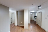 Located on Jasper Avenue NW in downtown Edmonton, this 2-bedroom, 2-bathroom unit offers a well-designed single-level layout with a functional and modern interior. Warm hardwood flooring runs throughout the space, complementing the clean white walls and neutral tones that create a bright, cohesive atmosphere.

The kitchen is well-appointed with granite countertops, white cabinetry, a tile backsplash, and black appliances including a French door refrigerator, electric range, and built-in microwave. A peninsula with an undermount double sink adds additional prep space and casual dining potential.

The open-plan living area benefits from dramatic floor-to-ceiling windows along the exterior wall, allowing views of the surrounding streetscape and filling the space with natural light. Both bedrooms are comfortably sized, with the primary bedroom featuring its own closet with wire shelving systems. A second closet provides additional storage.

The two bathrooms are clean and functional, with one featuring a full soaker tub and shower combination with tiled surrounds. In-unit laundry adds everyday convenience. The exterior facade showcases a contemporary curtain-wall glass design, giving the unit a modern urban character that reflects its downtown Edmonton location.