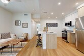 Located at 2700 N Perris Blvd in Perris, CA, this well-designed 2-bedroom, 2-bathroom single-story home offers a thoughtfully planned layout with modern finishes throughout. Light wood-style flooring flows continuously across the main living areas, creating a cohesive and bright aesthetic. The open-concept living, dining, and kitchen area serves as the heart of the home, featuring recessed lighting, a ceiling fan, and sliding glass doors that open to a private balcony, allowing natural light to fill the space. The kitchen is equipped with stainless steel appliances including a gas range, over-the-range microwave, and refrigerator, complemented by a center island with a white quartz countertop, an undermount sink, and light wood cabinetry. Both bedrooms are generously proportioned, with the primary bedroom offering ample closet space. The bathrooms feature matching light wood vanities, white countertops, and a tub-shower combination. Three closets provide abundant storage throughout the home. A dedicated laundry area adds everyday convenience. The attached garage offers secure parking and additional storage. Clean white walls and contemporary finishes give the entire home a fresh, modern character.