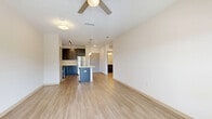 Located at 202 East Ufer Street in Fredericksburg, Texas, this well-appointed one-bedroom, one-bathroom residence offers a thoughtfully designed single-level layout. Light wood-look flooring flows throughout the main living areas, complemented by neutral walls and ceiling fans that enhance the bright, airy atmosphere.

The open-concept living and kitchen area serves as the heart of the home. The kitchen is outfitted with dark espresso cabinetry, stainless steel appliances including a refrigerator, range, and microwave, plus a striking granite-topped center island with a built-in sink and pendant lighting overhead — ideal for both meal prep and casual dining.

The living room is generously proportioned with large windows and a patio door that invite natural light and provide outdoor access to the private patio.

The bedroom is a comfortable retreat featuring plush carpeting, a ceiling fan, a window with outdoor views, and access to two closets — including a spacious walk-in closet with wire shelving and built-in storage shelving units.

The bathroom is finished with a granite-topped dark vanity, wood-look flooring, overhead cabinetry, and a tub/shower combination adorned with marble-style tile surround.

A dedicated laundry area rounds out the functional amenities of this efficiently designed Fredericksburg residence.
