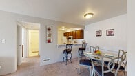 This single-floor, one-bedroom, one-bathroom unit at 900 Long Blvd in Lansing, Michigan offers a practical and comfortable layout across a well-utilized floor plan. The combined living and dining area serves as the heart of the home, featuring plush carpeting, neutral-toned walls, and a sliding glass door that allows natural light to fill the space and provides a view to the outdoors. The living area comfortably accommodates seating and entertainment arrangements, while the adjacent dining space includes a pass-through bar connecting to the kitchen, adding a convenient and social element to the layout.

The kitchen is efficiently designed with warm wood cabinetry, light countertops, tile flooring, and a full suite of white appliances including a refrigerator, electric range, and dishwasher. A double-basin sink completes the functional workspace.

The bedroom is a quiet, carpeted retreat with a natural light window and ample room for furnishings. Three closets throughout the unit provide generous storage. The bathroom features a full soaking tub and shower combination with clean white finishes and tile flooring. A hallway connects the rooms, contributing to the smooth and logical flow of this cozy, move-in-ready home.