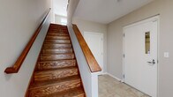 Located at 479-483 N Harlem Ave in Oak Park, Illinois, this three-bedroom, three-bathroom townhome spans three thoughtfully designed floors. The entry level welcomes you with tile flooring and a striking staircase featuring rich, warm-toned hardwood treads and a polished wood handrail. The main living floor offers an open-concept kitchen and living area bathed in natural light. The kitchen is outfitted with deep espresso cabinetry, granite countertops, stainless steel appliances, and pendant lighting, while the living area showcases gleaming hardwood floors and a staircase with clean white railings. The upper floor houses all three bedrooms, each carpeted for comfort, including a generously sized primary bedroom with its own access to a private balcony and walk-in closet with built-in shelving. The primary bathroom is a standout, featuring a corner soaking tub with tile surround, dual vanities with granite countertops, dark wood cabinetry, and large-format tile flooring. The additional bathrooms echo the same refined finishes with granite vanities and ample natural light. Throughout the home, neutral tones, crisp white trim, and consistent high-quality materials create a cohesive and polished aesthetic.