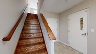 Located at 479-483 N Harlem Ave in Oak Park, Illinois, this three-bedroom, three-bathroom townhome spans three thoughtfully designed floors. The entry level welcomes you with tile flooring and a striking staircase featuring rich, warm-toned hardwood treads and a polished wood handrail. The main living floor offers an open-concept kitchen and living area bathed in natural light. The kitchen is outfitted with deep espresso cabinetry, granite countertops, stainless steel appliances, and pendant lighting, while the living area showcases gleaming hardwood floors and a staircase with clean white railings. The upper floor houses all three bedrooms, each carpeted for comfort, including a generously sized primary bedroom with its own access to a private balcony and walk-in closet with built-in shelving. The primary bathroom is a standout, featuring a corner soaking tub with tile surround, dual vanities with granite countertops, dark wood cabinetry, and large-format tile flooring. The additional bathrooms echo the same refined finishes with granite vanities and ample natural light. Throughout the home, neutral tones, crisp white trim, and consistent high-quality materials create a cohesive and polished aesthetic.