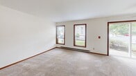 Located at 7601 Radcliffe Drive in Madison, WI, this 2-bedroom, 1-bathroom single-floor unit offers a practical and comfortable layout across a well-utilized footprint. The combined kitchen and living room serves as the heart of the home, with the living area highlighted by a tile-surround wood-burning fireplace and warm carpeting throughout. The galley-style kitchen is efficiently designed with oak cabinetry, dark granite-style countertops, tile flooring, a double stainless steel sink, and full appliances including an electric range, refrigerator, and dishwasher. The primary bedroom is generously sized, featuring plush carpet, multiple windows that invite natural light, and a dedicated closet. The second bedroom also offers carpeted flooring, natural light through wood-framed windows, and its own closet space with built-in shelving. The full bathroom includes a granite-style vanity countertop, a tub/shower combination, and a large mirror. A dedicated laundry room with full-size washer and dryer and wire shelving adds everyday convenience. Warm wood trim and baseboards carry a consistent, classic aesthetic throughout the unit.