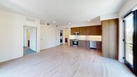 Located in the heart of San Diego's vibrant downtown at 372 Fourth Ave, this modern single-floor residence offers a thoughtfully designed open-concept layout with clean lines and contemporary finishes throughout. Light hardwood flooring extends through the entryway, living area, and kitchen, creating a warm and cohesive aesthetic.

The spacious living and dining area is bathed in natural light from a large glass door that opens to city views, lending an airy, connected feel to the space. The kitchen is well-appointed with rich dark wood cabinetry extending to the ceiling, a classic white subway tile backsplash, light countertops, and a full suite of stainless steel appliances including a range, over-the-range microwave, dishwasher, and refrigerator. A stacked washer and dryer unit is conveniently integrated into the main living area.

The two bedrooms feature plush carpeting and windows framing views of the surrounding San Diego cityscape. The primary bathroom offers a dual-sink vanity with wood cabinetry, a large mirror, and a walk-in tiled shower. The secondary bathroom includes a soaking tub with a fully tiled surround, a single vanity, and neutral tile flooring. A clean, well-lit entry hallway with hardwood flooring completes this modern urban residence.
