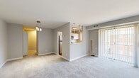 Located at 3100 Southgate Drive in Alexandria, Virginia, this two-bedroom, one-bathroom residence offers a thoughtfully designed single-floor layout. The open living and dining area is finished with plush carpeting and neutral gray walls, creating a bright and versatile space. A sliding glass door with vertical blinds fills the living room with natural light and provides direct outdoor access. The pass-through kitchen connects seamlessly to the main living area and features white cabinetry, light wood-look flooring, a window over the sink, and stainless steel appliances including a refrigerator, gas range, and dishwasher. The bathroom is appointed with a full soaking tub and floor-to-ceiling wood-look gray tile, adding a refined, contemporary touch. The spacious primary bedroom benefits from two windows that invite ample natural light and overlook the surrounding neighborhood. A generous walk-in closet with dual wire shelving and hanging rods provides excellent storage. The second bedroom is carpeted and comfortably sized, with its own closet access. Throughout the residence, clean white trim, consistent neutral tones, and a practical floor plan combine to create a cohesive and comfortable living environment.