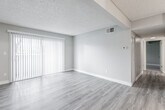 This single-floor, 2-bedroom, 1-bathroom unit in Rancho Cordova, California offers a clean and functional layout well-suited for comfortable living. The open living and dining area is finished with wood-look laminate flooring that extends throughout the main living spaces, lending a warm and cohesive feel. A large sliding glass door with vertical blinds invites natural light into the living area, creating a bright and airy atmosphere. A ceiling fan provides additional comfort in the adjoining space, which connects seamlessly toward the front entry. The kitchen features white cabinetry and a peninsula-style counter, providing ample storage and prep space. Both bedrooms are carpeted in soft, neutral-toned plush carpet and are equipped with louvered bi-fold closet doors, offering practical storage solutions. Each bedroom is served by a window fitted with horizontal blinds, allowing for controlled natural light. The shared full bathroom is finished with wood-look vinyl flooring, a white vanity with countertop storage, and a full tub-shower combination, all presented in a clean, bright white palette. Textured ceilings are featured throughout the unit, and neutral gray walls create a versatile backdrop throughout this well-maintained Rancho Cordova residence.