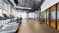Located at 1590 Elmwood Ave in Evanston, IL, this contemporary fitness center offers a well-appointed, open-plan layout across a single floor. The space features an exposed ceiling with dark-painted ductwork and structural elements, lending an industrial aesthetic complemented by sleek linear pendant lighting and accent spotlights. Durable rubber flooring spans the entire area, providing a safe and functional surface throughout.

Large floor-to-ceiling windows line one side of the facility, flooding the space with natural light and offering views of the surrounding greenery. A dedicated cardio zone houses a row of Life Fitness treadmills, ellipticals, and stationary bikes positioned along the windowed wall. The strength training area includes a variety of cable machines, a functional trainer, and a full dumbbell rack with adjustable benches, all set against a mirrored wall that enhances the sense of space.

A glass-partitioned studio room provides a separate area for group classes or focused training sessions, featuring a hardwood floor visible through the transparent walls. Completing the space is a motivational athletic figure mural on a gray accent wall, adding a dynamic visual element to the overall design. The facility's modern, industrial aesthetic and comprehensive equipment selection create an energetic and functional environment suited for a full range of fitness activities.