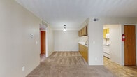 Located at 4606 Ridgeway Cir in Kalamazoo, Michigan, this single-floor unit offers a practical and functional layout designed for comfortable everyday living. The open-concept living and dining area is finished with wall-to-wall carpeting and neutral-toned walls, creating a bright and welcoming atmosphere. A pendant light fixture anchors the dining space, while a ceiling vent ensures consistent climate control throughout. The kitchen is positioned adjacent to the living area and features a peninsula-style counter with warm wood-toned cabinetry above and below. It is equipped with a white refrigerator, electric range, built-in microwave, and a double-basin sink — providing all essential appliances in a compact, efficient layout. The bedrooms are carpeted and generously lit by large windows that bring in natural light and offer views of the surrounding neighborhood. One bedroom includes a sliding glass door fitted with vertical blinds, adding an additional source of light and outdoor access. The bathroom is clean and functional, featuring a wide vanity with a single-basin sink, brushed nickel fixtures, a large mirror, and a toilet — all finished in neutral tones. Additional features include interior doors with warm wood finishes, a thermostat, and multiple storage closets accessible from the main hallway.