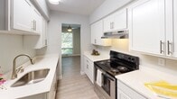 Located along US-12 in Wayzata, Minnesota, this single-floor residence offers a well-organized layout with updated finishes throughout. The spacious living area serves as the centerpiece of the home, featuring wood-style hard flooring, neutral gray walls, and a textured ceiling. Large vertical blinds frame a sliding glass door that invites natural light and provides views of the surrounding greenery, while an additional window further brightens the space. A ceiling fan fixture adds both function and visual interest to the room.

The galley-style kitchen is efficiently designed with white shaker cabinetry, light quartz countertops, a stainless steel sink, and a stainless electric range with an overhead ventilation hood. Light wood-style flooring runs through the kitchen, which opens directly into the main living area for a connected feel.

The bedroom features plush carpeting, soft neutral tones, a textured ceiling, and a window that allows natural light to filter in. The full bathroom is clean and bright, with white cabinetry, a white countertop vanity, wood-style flooring, and a tiled tub-shower combination. The overall aesthetic is fresh, cohesive, and move-in ready.