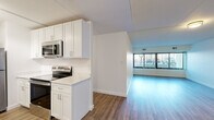 This thoughtfully designed 2-bedroom, 2-bathroom residence offers a functional and modern living experience across a single floor. The open-concept kitchen and living area form the heart of the home, where the kitchen showcases crisp white shaker cabinetry, quartz countertops, and a full suite of stainless steel appliances, including a refrigerator, electric range, and over-the-range microwave. Wood-look flooring flows seamlessly throughout the unit, lending warmth and continuity to every room. The spacious living room benefits from a large window wall fitted with vertical blinds, filling the space with natural light and offering exterior views. Both bedrooms are generously sized, with the primary bedroom providing ample room for furnishings, complemented by closet storage. Each bedroom continues the wood-look flooring and maintains a clean, neutral palette. The two bathrooms are finished to a high standard, featuring white vanities with quartz countertops, light grey tile flooring, and striking dark marble-look tile surrounds — one bathroom with a walk-in shower and the other with a soaking tub and shower combination. Two dedicated closets provide additional storage throughout the residence. The overall aesthetic is modern, clean, and move-in ready.