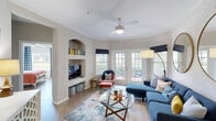 Located in Sarasota, FL, this thoughtfully designed 3-bedroom, 2-bathroom residence offers a cohesive blend of contemporary style and comfortable living across a single floor. The open-concept living room is a standout, featuring light wood-style flooring, a ceiling fan, built-in arched shelving, and French doors that lead to a private patio with outdoor views. A patterned accent wall and dual gold-framed circular mirrors add a bold, curated touch to the space. The kitchen is well-appointed with white cabinetry, marble-look countertops, stainless steel appliances, and a deep single-basin sink — all finished with clean, modern details. The primary bedroom makes a striking impression with a vibrant red geometric-patterned accent wall, ceiling fan, and ample natural light. A second bedroom features a deep navy accent wall, plaid curtains, and a window with pleasant outdoor views. Both bathrooms are finished with marble-look vanity countertops, white cabinetry, and tub-shower combinations with tile surrounds. Two closets and dual hallways provide practical storage and circulation throughout. The overall ambiance is energetic yet inviting, with bold color choices and contemporary finishes defining each room.