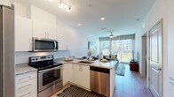 This thoughtfully designed single-floor residence showcases a contemporary open-concept layout that seamlessly integrates the kitchen, dining, and living areas into one cohesive space. The kitchen is equipped with stainless steel appliances, including an electric range, built-in microwave, and dishwasher, all complemented by crisp white cabinetry and granite countertops. A peninsula with bar seating serves as both a functional workspace and a casual dining area, making it ideal for entertaining. Light wood-style flooring flows throughout the main living areas, enhancing the bright, airy atmosphere.

The living room is a comfortable retreat featuring a ceiling fan, large floor-to-ceiling windows, and a sliding glass door that opens to a private balcony with outdoor views, inviting plentiful natural light into the space. A bold abstract artwork anchors the living area, adding a vibrant touch to the neutral palette.

The bedroom is generously sized, featuring a large window with outdoor views of lush landscaping, wood-style flooring, and clean white walls. The bathroom is finished with granite countertops, white cabinetry, and a vessel sink, maintaining the cohesive modern aesthetic found throughout. Overall, this residence offers a clean, functional, and stylish living environment.
