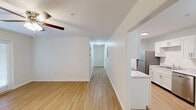 Located in New Market, Alabama, this single-floor, 3-bedroom, 2-bathroom home offers a clean, modern design throughout. Light-toned hardwood-style flooring flows seamlessly across all rooms, creating a bright and cohesive aesthetic complemented by crisp white walls and white trim.

The open living area is anchored by a ceiling fan and connects directly to the kitchen, which features white shaker-style cabinetry, light stone-look countertops, and stainless steel appliances including a refrigerator, range, built-in microwave, and sink. The galley-style layout maximizes efficiency while maintaining a polished look.

A central hallway leads to all three bedrooms, each featuring natural light from blinds-covered windows and the same warm flooring found throughout the home. The spacious primary bedroom offers generous room to furnish comfortably and includes access to a dedicated walk-in closet fitted with wire shelving systems for organized storage.

Both bathrooms maintain the home's consistent design language, featuring white cabinetry with brushed nickel hardware, marble-look countertops, tub-shower combinations, and matching flooring. The overall ambiance of this home is bright, clean, and functional, making it a practical and inviting residence.