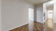 Located at 787 Vaughan Rd in Toronto's vibrant Oakwood-Vaughan neighbourhood, this 2-bedroom, 1-bathroom unit offers a practical and well-organized layout across a single floor. Warm parquet flooring runs throughout the living areas and bedrooms, adding a classic character to the space. The galley-style kitchen is notably updated, featuring white shaker cabinetry, dark granite countertops, a mosaic tile backsplash, and stainless steel appliances including a refrigerator, electric range, and over-the-range microwave — all set over light terrazzo-style flooring. The living and dining areas provide a connected, open feel with neutral grey walls and clean white baseboards. The primary bedroom is generously proportioned, benefiting from a large sliding glass door panel and direct access to adjacent rooms. Both bedrooms feature parquet flooring, radiator heating units, and windows that bring in natural light. Crown moulding accents select rooms, adding a touch of architectural detail. The bathroom is finished with crisp white tile, a bold black accent border, a soaker tub with overhead shower, a floating vanity with an undermount sink, and a mirrored medicine cabinet. The unit presents a clean, move-in-ready interior with functional design throughout.