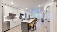Located at 1090 W Hampden Ave in Englewood, Colorado, this thoughtfully designed 2-bedroom, 2-bathroom residence offers a comfortable and modern living experience across a single floor. The open-concept layout seamlessly connects the kitchen, dining area, and living room, creating an inviting and functional space ideal for everyday living and entertaining.

The kitchen is a standout feature, outfitted with crisp white shaker cabinetry, a gray subway tile backsplash, stainless steel appliances, and a spacious center island with bar seating — perfect for casual dining. Light-toned luxury vinyl plank flooring runs throughout, adding warmth and continuity across the living spaces.

The living room benefits from large windows that allow natural light to fill the room, complemented by recessed lighting and clean white walls. The primary bedroom is generously sized, featuring a ceiling fan and direct access to its own bathroom. Both bathrooms are finished with large-format tile flooring, white vanities, and sleek matte black fixtures. The second bathroom includes a soaking tub and shower combination.

Each bedroom is supported by a dedicated closet featuring built-in shelving and hanging rods, offering ample organization. The overall aesthetic is clean, contemporary, and move-in ready, making this residence a refined and practical home in the Denver metro area.