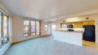 Located at 2733 Shadow View Dr in Eugene, Oregon, Unit 312 is a single-floor residence designed with a clean, functional layout. The open-concept living and dining area is expansive, featuring plush carpeting and large windows that flood the space with natural light while offering views of the surrounding community. A private balcony extends the living space outdoors.

The kitchen is thoughtfully designed with warm wood cabinetry, granite-style countertops, and a full suite of black appliances including a refrigerator, range, microwave, and dishwasher. A peninsula counter separates the kitchen from the living area, creating a practical and social flow. Light hardwood flooring runs throughout the kitchen and entry hallway.

The primary bedroom is generously proportioned with soft carpeting, mirrored sliding closet doors offering ample storage, and an additional open closet alcove. A second bedroom provides comfortable space with its own window and carpeted floor. A third, more compact bedroom also features a window with community views.

Two full bathrooms each include a tub/shower combination, granite-topped vanities with wood cabinetry, and tile flooring. The entry hallway includes a utility access panel and a programmable thermostat, completing this well-appointed and move-in-ready residence.