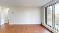 Located at 383 Albert St in Waterloo, Ontario, this one-bedroom unit offers a practical and well-laid-out single-floor plan. The open-concept kitchen and living area forms the heart of the space, creating a cohesive and functional environment. The kitchen is equipped with dark espresso cabinetry, a light stone-finish countertop that extends into a peninsula island, stainless steel appliances including a full-size refrigerator, and a tiled backsplash above the sink. Warm hardwood-style flooring flows consistently throughout the entire unit, complementing the neutral, light-toned walls and white baseboards. The living area is bright and open, with a window that brings in natural light and provides views of the surrounding neighbourhood. The bedroom is a comfortable size, featuring its own window for additional natural light, a built-in sliding-door closet offering ample storage, and a textured ceiling finish consistent with the rest of the unit. A full bathroom is also present, as seen in the floor plan view. The overall ambiance is clean, understated, and functional, making this a straightforward and practical living space in the heart of Waterloo.