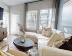 This contemporary apartment in Kissimmee, Florida, offers 970 square feet of thoughtfully designed living space. The unit features two bedrooms, including a spacious primary bedroom of 190 square feet, and two full bathrooms. The open-concept floor plan creates a seamless flow between the living areas, enhancing the sense of space.

The kitchen is a highlight, boasting sleek white cabinetry, stainless steel appliances, and a convenient island with seating. The living room is bathed in natural light from large windows and features a stylish accent wall, creating a cozy yet modern atmosphere. Both bedrooms are well-appointed, with the primary bedroom offering ample space and an en-suite bathroom.

Throughout the apartment, warm wood-tone flooring adds warmth and continuity. The bathrooms are elegantly designed with modern fixtures and finishes. Practical amenities include in-unit laundry and generous closet space, ensuring both comfort and convenience.

The apartment's decor is contemporary and inviting, with a neutral color palette accented by pops of color in the furnishings and artwork. This harmonious blend of style and functionality makes this apartment an ideal urban retreat in the heart of Kissimmee.