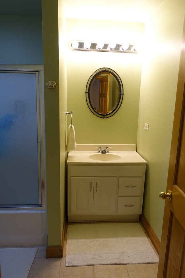 Full bath with tub and sliding shower doors. - 3553 S Hermitage Ave