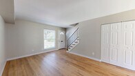 Located at 4381 Bonita Dr in Middletown, OH, this two-story home offers a practical and well-appointed layout across two floors. The main level features a welcoming living room with warm-toned hardwood flooring, neutral gray walls, and a front entry door with a transom window that allows natural light to fill the space. A sleek staircase with wood treads and a black metal railing connects the main level to the upper floor. Sliding glass doors on the exterior provide convenient outdoor access to a paved patio area. Upstairs, two bedrooms are finished with the same attractive hardwood flooring and soft neutral tones. Both bedrooms include built-in closets with paneled double doors, and windows that bring in natural light. The primary bedroom offers a comfortable and functional layout with ample closet storage. The single full bathroom is well-designed, featuring a white vanity with shaker-style cabinetry, a tub/shower combination adorned with striking marble-style wall surround, and matching hardwood flooring. A hallway connects the upper-level rooms efficiently. Throughout the home, consistent finishes and clean lines create a cohesive, move-in-ready aesthetic suitable for a variety of lifestyles.