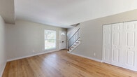 Located at 4381 Bonita Dr in Middletown, OH, this two-story home offers a practical and well-appointed layout across two floors. The main level features a welcoming living room with warm-toned hardwood flooring, neutral gray walls, and a front entry door with a transom window that allows natural light to fill the space. A sleek staircase with wood treads and a black metal railing connects the main level to the upper floor. Sliding glass doors on the exterior provide convenient outdoor access to a paved patio area. Upstairs, two bedrooms are finished with the same attractive hardwood flooring and soft neutral tones. Both bedrooms include built-in closets with paneled double doors, and windows that bring in natural light. The primary bedroom offers a comfortable and functional layout with ample closet storage. The single full bathroom is well-designed, featuring a white vanity with shaker-style cabinetry, a tub/shower combination adorned with striking marble-style wall surround, and matching hardwood flooring. A hallway connects the upper-level rooms efficiently. Throughout the home, consistent finishes and clean lines create a cohesive, move-in-ready aesthetic suitable for a variety of lifestyles.