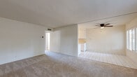 Located in Walnut Creek, CA, this single-floor residence offers a clean, functional layout with a bright and neutral aesthetic throughout. The open living area features soft wall-to-wall carpeting and transitions seamlessly into the kitchen, which is finished with white tile flooring. Plantation shutters on the front-facing windows allow for adjustable natural light, while a ceiling fan adds both functionality and a finishing touch to the space.

The galley-style kitchen is well-appointed with white cabinetry extending to the ceiling, tile backsplash, a double-basin sink, and white appliances including a range and refrigerator. Overhead lighting keeps the space well-lit, and the layout maximizes efficiency within the corridor-style design.

The bedrooms are carpeted and feature mirrored sliding closet doors that reflect light and contribute to a sense of openness. One bedroom includes a sliding glass door that opens to an outdoor patio area, offering a view of mature trees and surrounding greenery.

The bathroom is finished with tile flooring and includes a tub-shower combo with tile surround, a vanity with under-sink storage, and a toilet. The overall palette of the home is light and neutral, creating a versatile canvas throughout.
