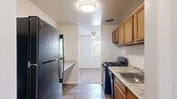 Located at 6112 Edsall Rd in Alexandria, Virginia, this two-bedroom, one-bathroom residence offers a practical and comfortable single-floor layout. The expansive living room is a standout feature, showcasing plush wall-to-wall carpeting, crisp white walls, and generous natural light streaming through large sliding glass doors fitted with vertical blinds — creating a bright, open atmosphere. A separate window adds additional daylight to the space, which flows seamlessly into the dining area.

The galley-style kitchen is well-appointed with warm wood cabinetry, granite-look countertops, a subway tile backsplash, and wood-look flooring. It includes black appliances — a gas range and a full-size refrigerator — and connects directly to the dining area via an open passageway, making it convenient for everyday living and entertaining.

The primary bedroom is generously sized, featuring soft carpeting and a bright window with blinds that invite natural light while maintaining privacy. The second bedroom mirrors this comfortable aesthetic. Four closets throughout the unit provide ample storage.

The bathroom is elegantly finished with large-format marble-look tile surrounding a full soaking tub, offering a clean and refined look. An entrance foyer and hallway complete the thoughtfully organized layout of this Alexandria residence.
