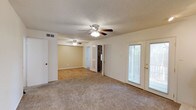 This single-story residence at 5303 11th Street in Lubbock, Texas offers a practical and comfortable layout throughout. The main living area is generously sized, featuring neutral carpet, a ceiling fan with light fixture, and French doors that open to an outdoor space, allowing natural light to fill the room. A standout feature of the living area is a brick-surround fireplace, adding a classic focal point to the space.

Adjacent to the living area, a secondary carpeted room with warm-toned walls and its own ceiling fan provides flexible use as a dining or sitting area, with wood-look flooring visible in the connecting hallway beyond.

The kitchen is equipped with wood-toned cabinetry offering ample upper and lower storage, light countertops, a white electric range with overhead ventilation, and wood-look flooring. Multiple bedrooms throughout the home are carpeted and feature ceiling fans with lighting and windows fitted with blinds for natural light and privacy.

The bathrooms include a full tub-shower combination, toilet, and a vanity with white cabinetry and countertop. Hallways connect the rooms efficiently, with closet space integrated along the corridors. Textured ceilings are consistent throughout the home.