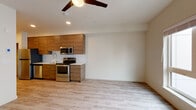 Located at 3214 Broadway in Everett, WA, Unit 710 is a thoughtfully designed single-floor residence offering a clean, modern aesthetic throughout. The open-concept layout seamlessly connects the kitchen and living area, creating a spacious and functional environment. Light wood-look flooring extends throughout the unit, complementing the neutral wall tones and contributing to a bright, airy ambiance.

The kitchen is a standout feature, outfitted with warm wood-grain cabinetry that reaches the upper walls, white countertops, a stainless steel undermount sink with a contemporary gooseneck faucet, and a full suite of stainless steel appliances including a refrigerator, electric range, microwave, and dishwasher. A tile backsplash adds a refined finishing touch.

The living area benefits from large windows that draw in abundant natural light, and a ceiling fan adds both comfort and style. The bedroom is generously proportioned, also featuring a large window with views of the surrounding area and continued light flooring.

The bathroom is clean and modern, featuring a wood-grain vanity with a white quartz countertop, an oversized mirror with bright vanity lighting, and a shower/tub combination. Light flooring carries through from the rest of the unit, maintaining a cohesive design. This unit offers a fresh, contemporary living environment in a well-appointed Everett location.