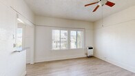 Located at 463 Hartford Ave, Unit 202, in Los Angeles, CA, this efficiently designed single-floor unit offers a thoughtful layout across four distinct spaces: a living room, kitchen, bathroom, and closet. The living room is bright and airy, featuring light wood-style flooring, crisp white walls, a textured ceiling with a ceiling fan, and large windows fitted with horizontal blinds that invite natural light and frame views of the surrounding Los Angeles neighborhood. A wall-mounted heater provides in-unit climate control. The kitchen is clean and functional, showcasing white shaker-style cabinetry — both upper and lower — paired with granite-look countertops and a stainless steel sink. A window above the counter further brightens the space. The bathroom is a standout, featuring a classic clawfoot soaking tub with an overhead shower fixture, tile flooring, and a clean, minimalist aesthetic that adds a charming, vintage character to the unit. A dedicated closet provides practical storage. Throughout the unit, the consistent use of light tones, wood-style flooring, and white finishes creates a cohesive, clean ambiance well-suited to urban living in the heart of Los Angeles.