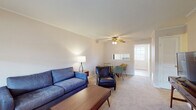 Located at 1450 Haft Dr in Reynoldsburg, Ohio, this single-floor residence offers a practical and comfortable layout spread across several well-defined living spaces. The living room serves as the central gathering area, featuring neutral-toned carpet, light-filled windows with horizontal blinds, and a ceiling fan with integrated lighting. The open sightline from the living area toward the dining space and kitchen creates a connected, functional flow throughout the unit.

The kitchen is equipped with a gas range, a stainless steel sink, and abundant dark wood cabinetry providing ample storage. A pass-through window connects the kitchen to the living and dining areas, enhancing the sense of openness. The dining area accommodates a small table and chairs, positioned near additional natural light.

The space includes two bedrooms, both finished with plush carpet and neutral walls. The primary bedroom offers generous floor space, while the secondary bedroom is well-suited for use as a guest room or home office. A full bathroom features a soaking tub with a built-in surround that includes recessed shelving. The overall ambiance throughout the space is calm and understated, with a straightforward layout well-suited for everyday living.