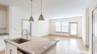 Located at 8251 Windsor Hill Blvd in North Charleston, SC, this well-appointed 2-bedroom, 2-bathroom residence offers a thoughtfully designed single-floor layout with modern finishes throughout. The open-concept kitchen and living area serves as the heart of the home, anchored by a central island with a granite countertop, an undermount sink, and stylish pendant lighting. White shaker cabinetry, a subway tile backsplash, and a full suite of stainless steel appliances — including a refrigerator, range, and microwave — complete the kitchen. Light hardwood flooring flows seamlessly from the kitchen through the living room, which benefits from natural light streaming in through large windows and provides access to an exterior door. Both bedrooms are carpeted and feature ceiling fans and windows that invite natural light. The primary bedroom offers a comfortable, well-proportioned retreat. Two dedicated closets provide ample storage throughout the unit. The bathrooms are finished with granite-top vanities and white cabinetry, and one features a tiled tub-shower combination with chrome fixtures. The overall palette of crisp whites and neutral tones creates a clean, bright ambiance throughout this move-in-ready North Charleston residence.