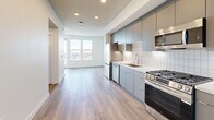 Located at 2260 El Cajon Boulevard in San Diego's vibrant North Park neighborhood, this modern one-bedroom, one-bathroom unit delivers a clean, contemporary aesthetic throughout. The open-concept living area seamlessly connects the kitchen, dining, and living spaces, all finished with light wood-tone luxury vinyl plank flooring that runs continuously underfoot. The kitchen is outfitted with stainless steel appliances — including a gas range, dishwasher, and microwave — complemented by sleek gray flat-front cabinetry, white quartz countertops, white subway tile backsplash, under-cabinet lighting, and a stainless steel undermount sink. Recessed lighting illuminates the space efficiently throughout. Large windows in the living area and bedroom invite abundant natural light and frame open city and hillside views, with a private balcony extending the living space outdoors. The bedroom features two closets, corner windows that maximize light, and a calm, neutral palette. The bathroom is appointed with large-format white wall tile, a glass-enclosed walk-in shower with gray accent tile, and wood-tone flooring. A dedicated laundry area and hallway storage round out this well-appointed, efficiently designed home.