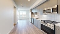Located at 2260 El Cajon Boulevard in San Diego's vibrant North Park neighborhood, this modern one-bedroom, one-bathroom unit delivers a clean, contemporary aesthetic throughout. The open-concept living area seamlessly connects the kitchen, dining, and living spaces, all finished with light wood-tone luxury vinyl plank flooring that runs continuously underfoot. The kitchen is outfitted with stainless steel appliances — including a gas range, dishwasher, and microwave — complemented by sleek gray flat-front cabinetry, white quartz countertops, white subway tile backsplash, under-cabinet lighting, and a stainless steel undermount sink. Recessed lighting illuminates the space efficiently throughout. Large windows in the living area and bedroom invite abundant natural light and frame open city and hillside views, with a private balcony extending the living space outdoors. The bedroom features two closets, corner windows that maximize light, and a calm, neutral palette. The bathroom is appointed with large-format white wall tile, a glass-enclosed walk-in shower with gray accent tile, and wood-tone flooring. A dedicated laundry area and hallway storage round out this well-appointed, efficiently designed home.