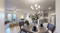 This thoughtfully designed 2-bedroom, 2-bathroom residence offers a comfortable and functional single-floor layout with a clean, contemporary aesthetic. Light wood-style flooring runs throughout, tying each space together cohesively.

The open-concept living, dining, and kitchen area forms the heart of the home. The living room is bathed in natural light from French doors that open to an outdoor area, and features a ceiling fan overhead. A dedicated dining space accommodates a full-sized table beneath an elegant chandelier. The kitchen is well-equipped with dark wood cabinetry, white countertops, stainless steel appliances, and ample storage, with direct access to an in-unit laundry room housing a full-sized washer and dryer.

The primary bedroom is a generous retreat with a ceiling fan, natural light from a large window, and dedicated closet space. The second bedroom is equally comfortable and well-proportioned. Both bedrooms feature light, neutral tones. The two bathrooms are clean and functional, with one featuring a tub-shower combination. A hallway connects the private areas of the residence, offering additional closet storage. The overall ambiance is bright, modern, and move-in ready.