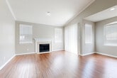 This thoughtfully designed single-floor home offers a comfortable and functional layout across two bedrooms and two bathrooms. The inviting living room immediately draws attention with its vaulted ceiling, warm hardwood flooring, a classic tile-surround fireplace, and multiple windows dressed with blinds that bathe the space in natural light. Adjacent to the living area, a dining or flex space features a sliding glass door with vertical blinds providing outdoor access, as well as an arched window detail that adds architectural character.

The kitchen is well-equipped with white raised-panel cabinetry, granite-look countertops, a decorative tile backsplash, and stainless steel appliances including a range and over-the-range microwave. A sliding glass door in the kitchen area offers additional outdoor connectivity.

Both bedrooms feature plush wall-to-wall carpet, crown molding, and ceiling fans with light fixtures. The spacious primary bedroom includes a walk-in closet and a bay-style window arrangement for added natural light. The bathrooms are clean and functional, with one featuring a full soaking tub and tiled surround. The dedicated laundry room includes wire shelving and washer/dryer hookups. Hallways and closets round out this efficiently organized floor plan.