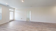 Located at 13035 Ardmore Forest Rd in Huntersville, NC, this single-floor residence offers a well-designed, open layout with a clean, modern aesthetic throughout. The living area is bright and spacious, showcasing light-toned hardwood-style flooring, crisp white walls, and elegant crown molding that lends a polished finish to the space.

The kitchen is a functional highlight, equipped with rich dark-brown cabinetry, granite countertops, a light subway tile backsplash, and a full suite of stainless steel appliances including a range, over-the-range microwave, and refrigerator. The kitchen flows seamlessly into the adjoining living and dining areas, making it ideal for everyday living and entertaining.

The bedrooms feature soft wall-to-wall carpeting and generous closet space, including sliding and hinged-door closets with built-in shelving and hanging rods. The primary bedroom is particularly well-appointed, offering dual closets and direct access to a private bathroom featuring granite vanity countertops, hardwood-style flooring, and a soaking tub with shower.

An additional full bathroom and well-proportioned secondary bedroom round out the layout. Throughout the home, recessed lighting, large windows with blinds allowing natural light, and consistent finishes create a cohesive and comfortable living environment.