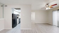 This efficient and thoughtfully laid-out one-bedroom, one-bathroom residence offers a clean, neutral aesthetic throughout its single floor. Light wood-style flooring flows seamlessly across all living areas, complementing the warm beige walls and bright white trim that define the space's cohesive look.

The open living area is anchored by a ceiling fan and receives natural light through a sliding glass door fitted with vertical blinds, providing direct access to an outdoor area. The galley-style kitchen is positioned adjacent to the living room and features white cabinetry, a granite-style countertop, a stainless steel sink, and black appliances including a refrigerator, range, and dishwasher. An overhead skylight lends additional brightness to the kitchen.

The bedroom is a comfortable, well-proportioned room with its own ceiling fan and a window with blinds that allows natural light. A spacious walk-in closet off the bedroom offers dual-sided shelving and hanging rods, providing generous storage capacity. The full bathroom includes a tub-shower combination with white tile surround, a granite-style vanity countertop, and wood-style flooring. The unit is further complemented by an in-unit laundry area and a hallway that connects the main living spaces efficiently.