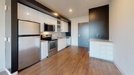 Located in Washington, DC's Capitol Hill neighborhood, this 2-bedroom, 4-bathroom residence offers a well-designed single-floor layout with modern finishes throughout. The kitchen serves as a functional centerpiece, featuring white cabinetry, open shelving, light gray subway tile backsplash, quartz-style countertops, a stainless steel undermount sink, and a full suite of stainless steel appliances including a range, dishwasher, refrigerator, and built-in microwave. Wood-style flooring runs throughout the main living areas, adding warmth to the contemporary aesthetic. The combined dining and living area provides an open, flexible space for everyday living. Both bedrooms are bright and airy, benefiting from large windows that frame views of the surrounding neighborhood. One bedroom features a sliding glass partition, while both include access to closets — one with a dedicated walk-in closet equipped with built-in shelving. The four bathrooms maintain the clean, modern design language of the home, with white subway tile walk-in showers, wood-tone flooring, and white vanities with chrome hardware. A dedicated laundry area rounds out this efficiently laid-out residence in a prime DC location.